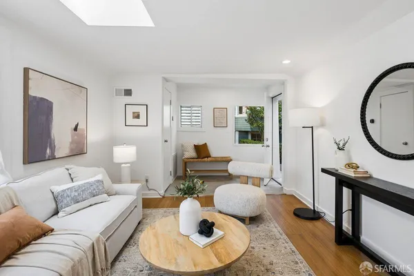 a living room with furniture and a mirror