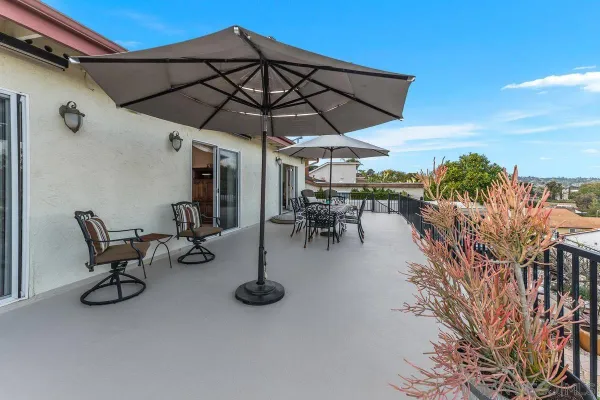 a view of a patio with table and chairs under an umbrella