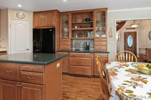 a kitchen with granite countertop a refrigerator and a stove top oven