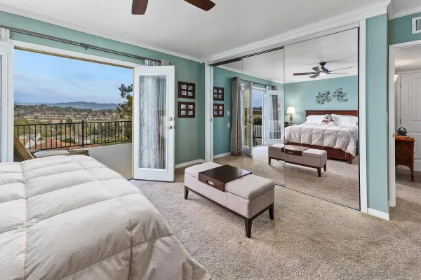 a spacious bedroom with a bed a couch and a large window