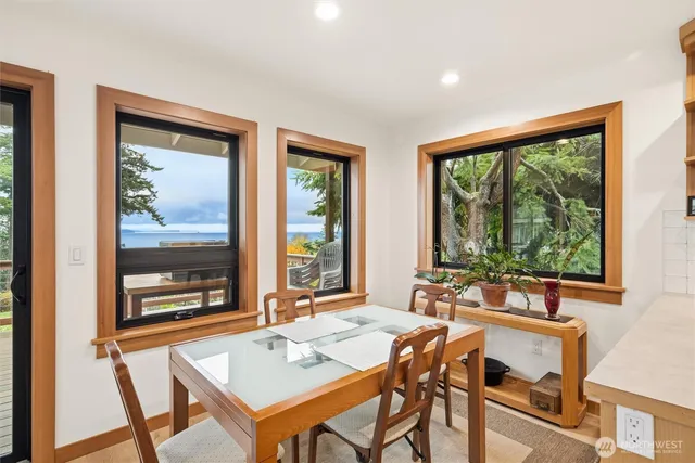 a view of a dining room with furniture large windows and wooden floor