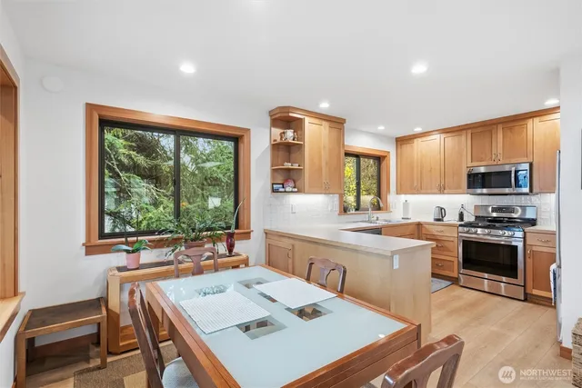 a large kitchen with kitchen island a large window in it