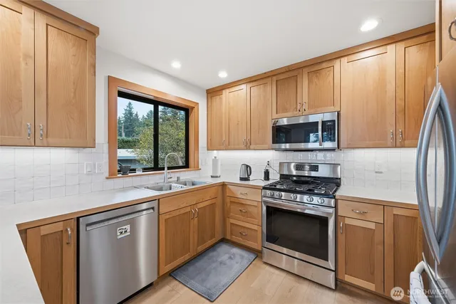 a kitchen with stainless steel appliances a stove sink microwave and cabinets