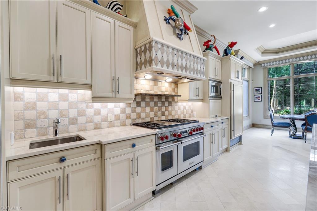 683 Hickory Road Naples, FL 34108 - Photo 13 of 42 a kitchen with a stove and cabinets