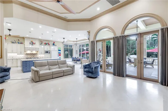 a living room with furniture a large window and wooden floors