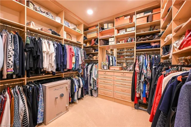 a view of walk in closet with clothes and shoes