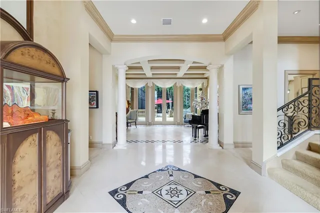a view of hallway with furniture and a chandelier