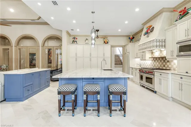 a large kitchen with stainless steel appliances granite countertop a stove a sink a dining table and chairs