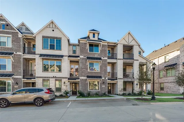 a front view of a residential apartment building with a yard