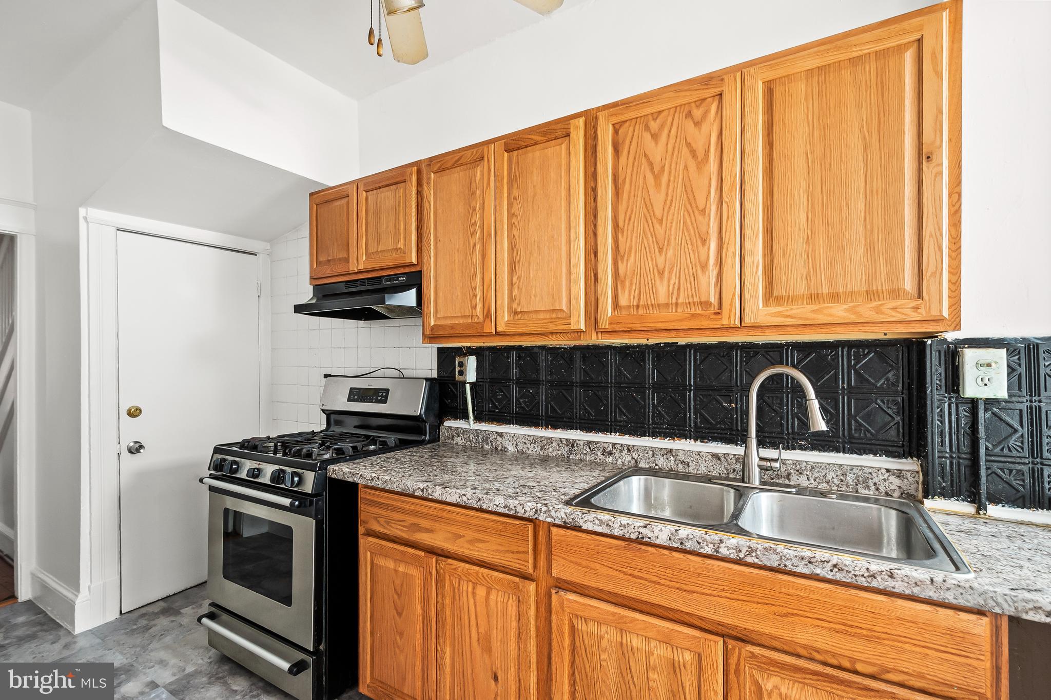 1214 Kennedy Street Northwest Washington, DC 20011 - Photo 12 of 34 a kitchen with granite countertop a sink stainless steel appliances a counter space and cabinets