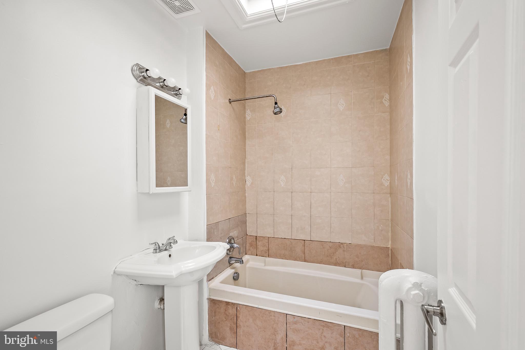 1214 Kennedy Street Northwest Washington, DC 20011 - Photo 19 of 34 a white bath tub sitting next to a white sink