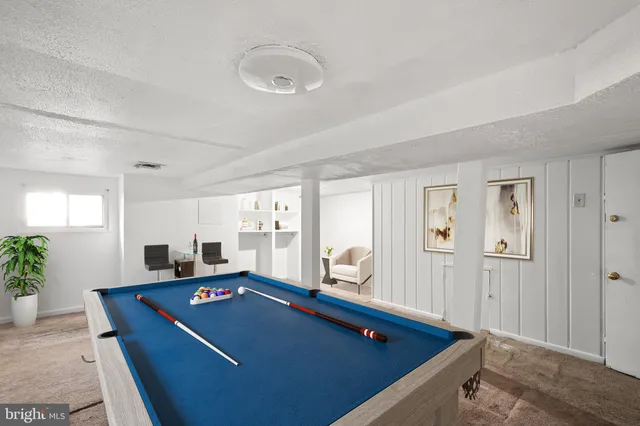 a living room with furniture pool table and window