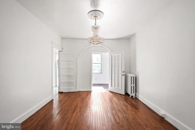 a view of a hallway with wooden floor and a window
