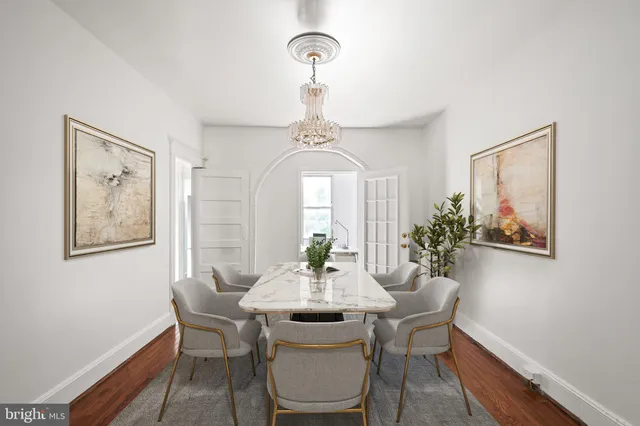 a dining room with furniture a potted plant and a chandelier