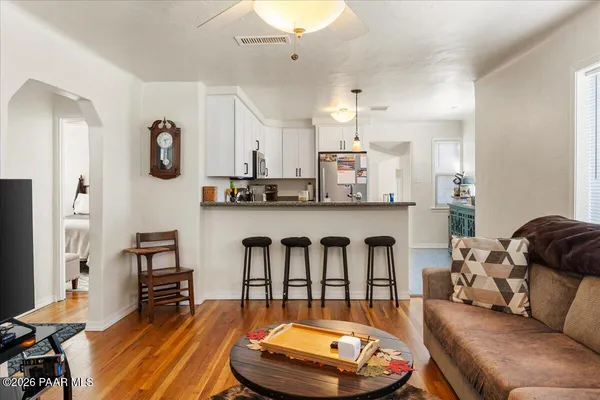 a living room with stainless steel appliances furniture and a view of kitchen