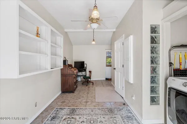 a view of a hallway with workspace and a window