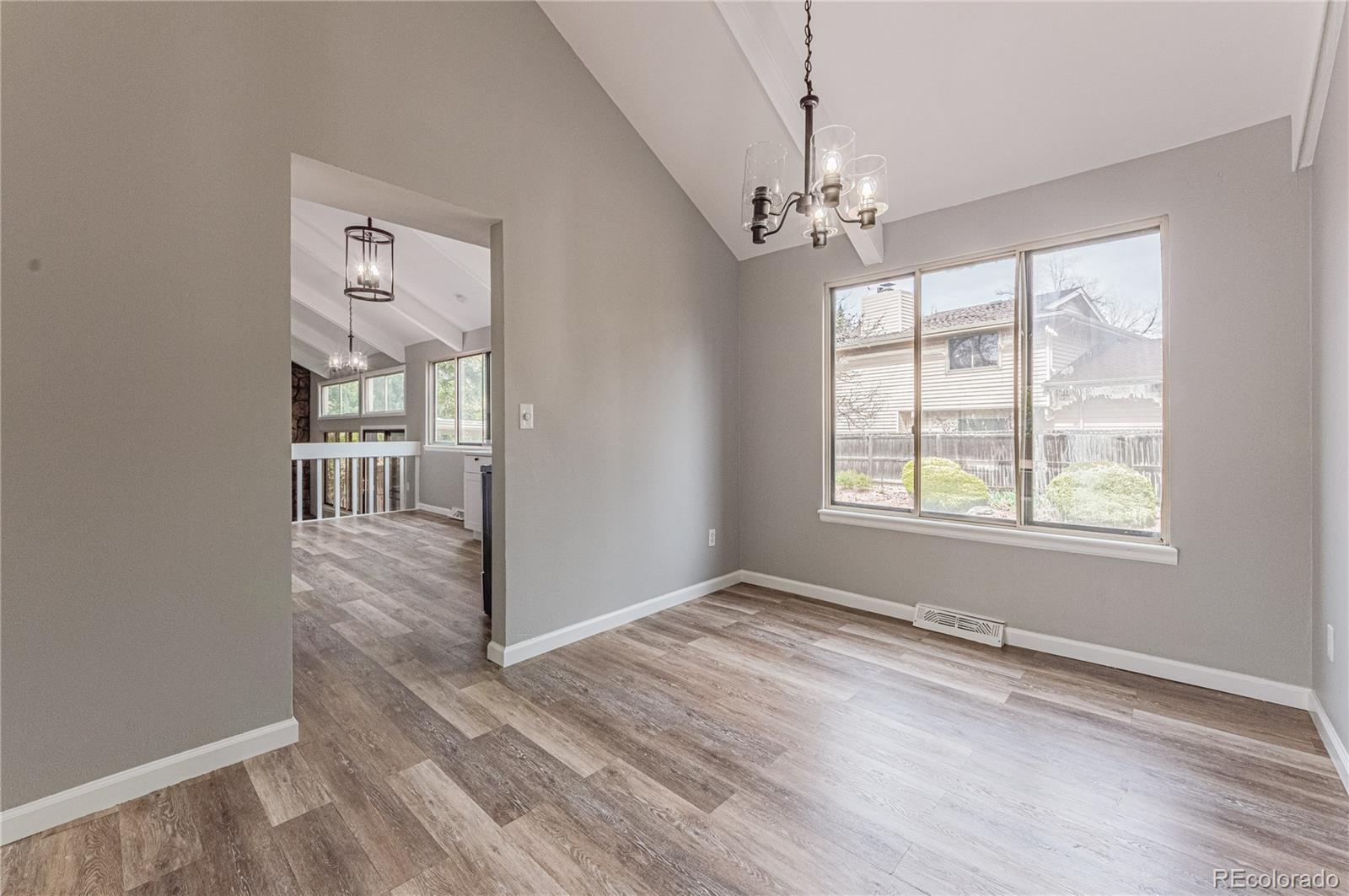 10091 Yates Street Westminster, CO 80031 - Photo 9 of 40 an empty room with wooden floor chandelier and windows