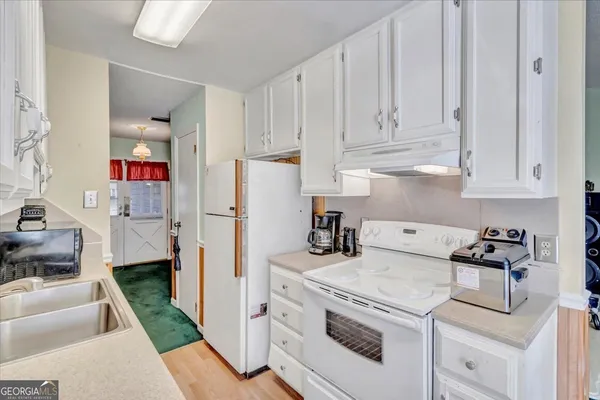 a kitchen with white cabinets and sink