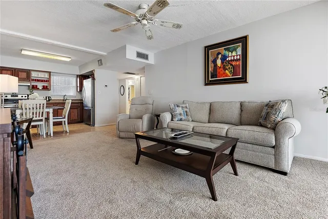 a living room with furniture kitchen view and a window