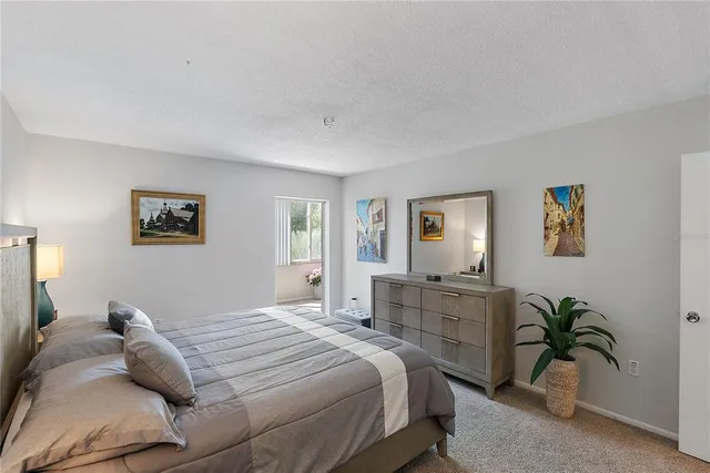 a bedroom with a large bed and a potted plant