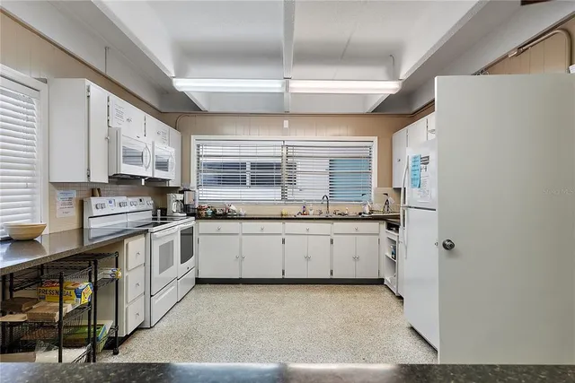 a view of a swimming pool with seating space and furniture