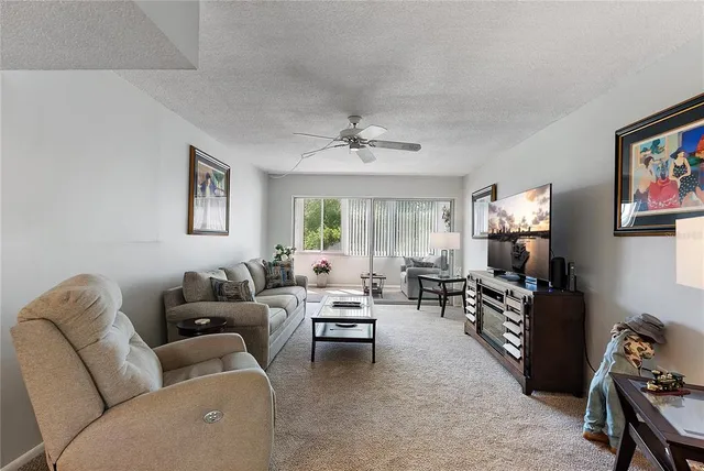 a living room with furniture ceiling fan and a window