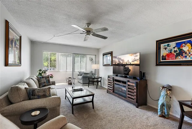 a living room with furniture a flat screen tv and a window