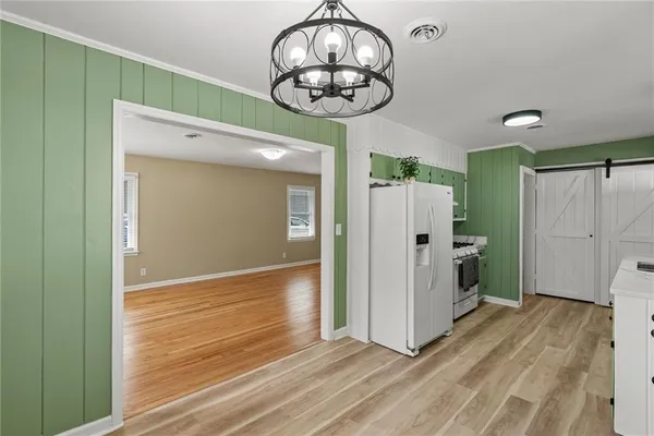 a view of a hallway with wooden floor and a window