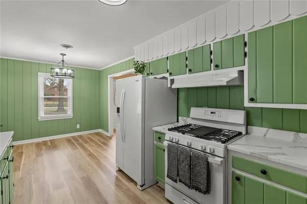 a kitchen with a refrigerator a stove and a wooden floors