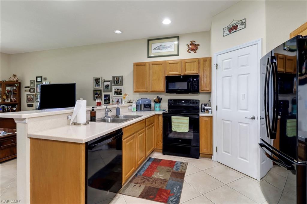 14174 Danpark Loop Fort Myers, FL 33912 - Photo 6 of 20 a kitchen with stainless steel appliances a stove top oven a sink a counter top space and cabinets