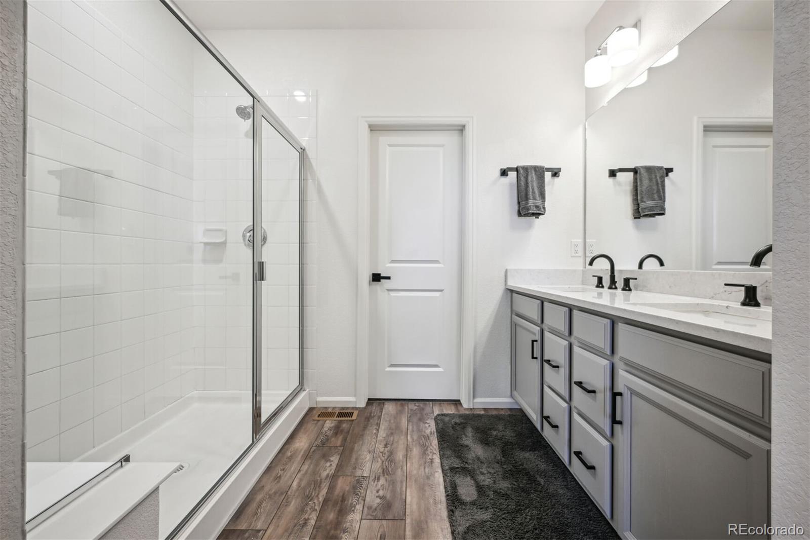 347 Felicity Loop Castle Rock, CO 80109 - Photo 14 of 28 a bathroom with a double vanity sink a mirror and a shower