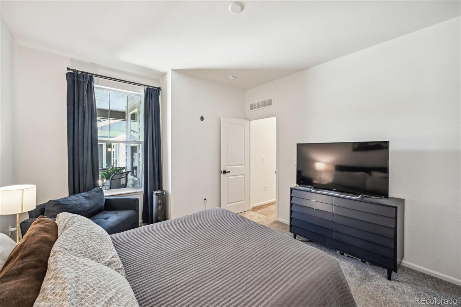 347 Felicity Loop Castle Rock, CO 80109 - Photo 16 of 28 a bedroom with a bed and a flat screen tv