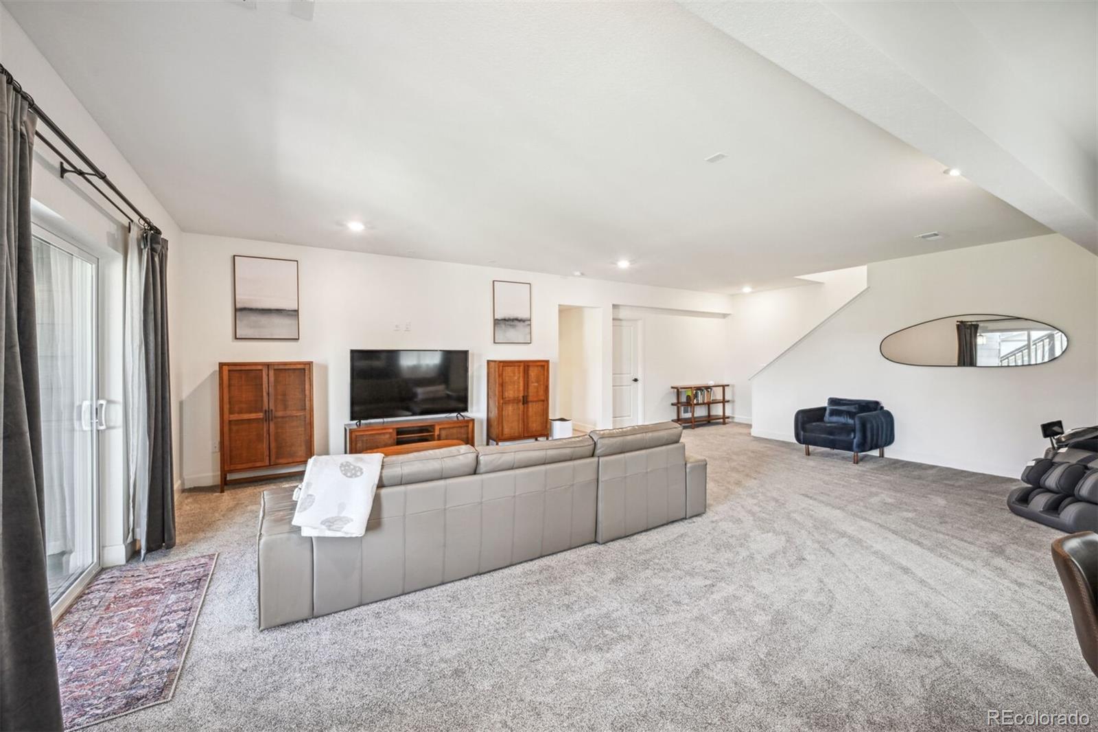 347 Felicity Loop Castle Rock, CO 80109 - Photo 22 of 28 a large living room with furniture and a flat screen tv