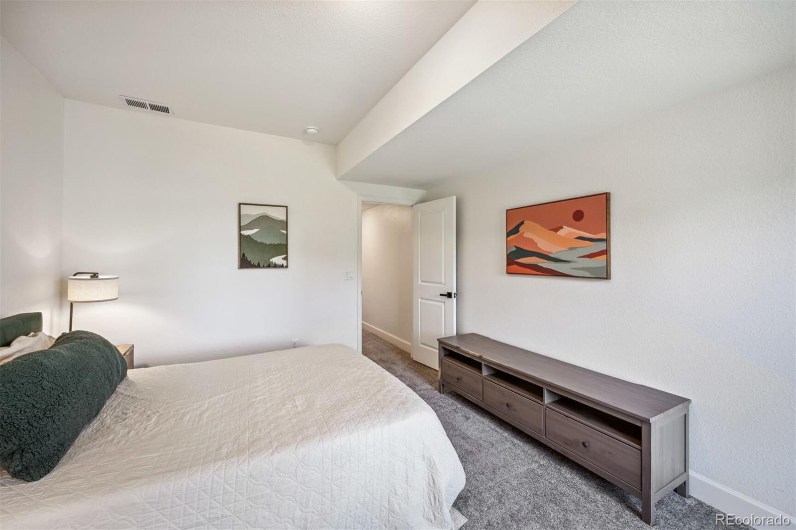 347 Felicity Loop Castle Rock, CO 80109 - Photo 24 of 28 a bedroom with bed and paintings on the wall