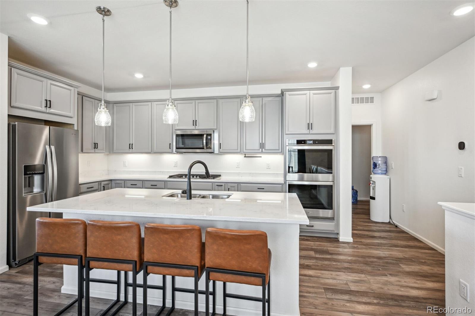 347 Felicity Loop Castle Rock, CO 80109 - Photo 9 of 28 a kitchen with stainless steel appliances granite countertop a table chairs refrigerator and microwave