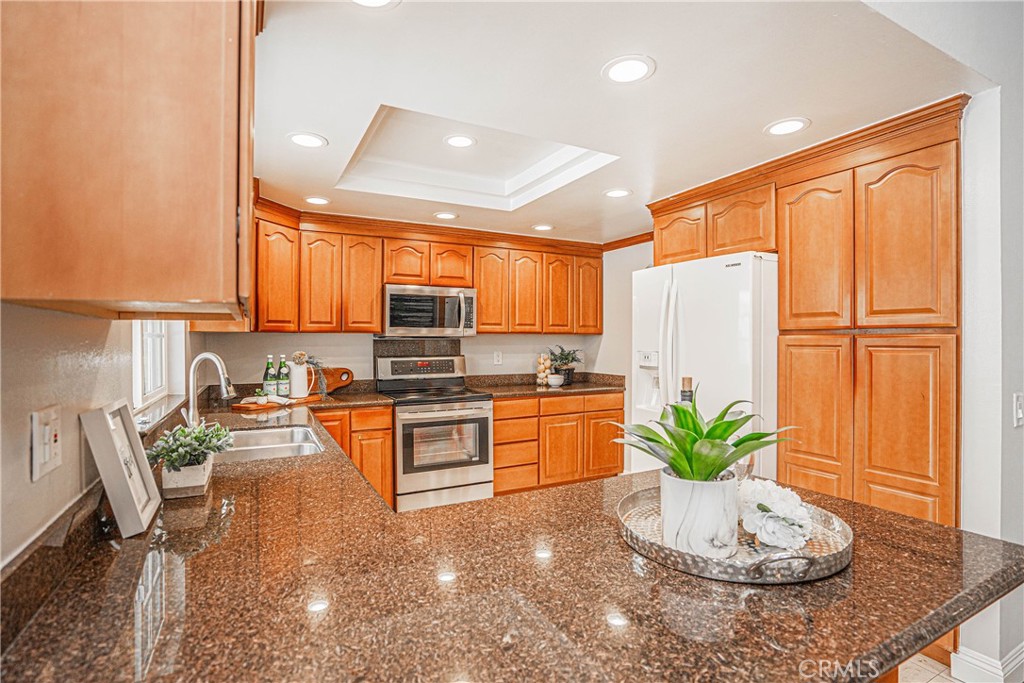 1301 Eltham Place Fullerton, CA 92833 - Photo 13 of 26 a kitchen with stainless steel appliances granite countertop a refrigerator a stove and a wooden cabinets