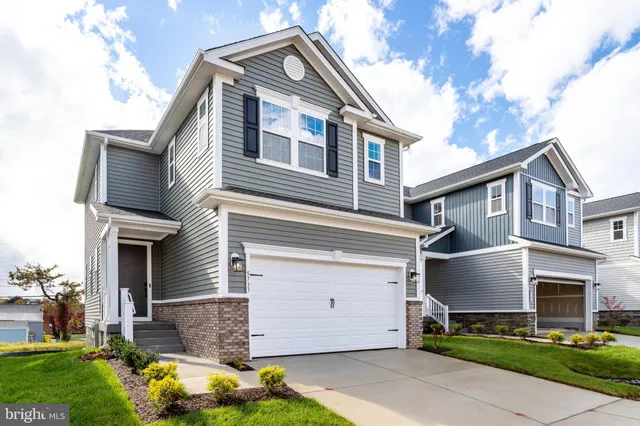 a front view of a house with a garden and plants