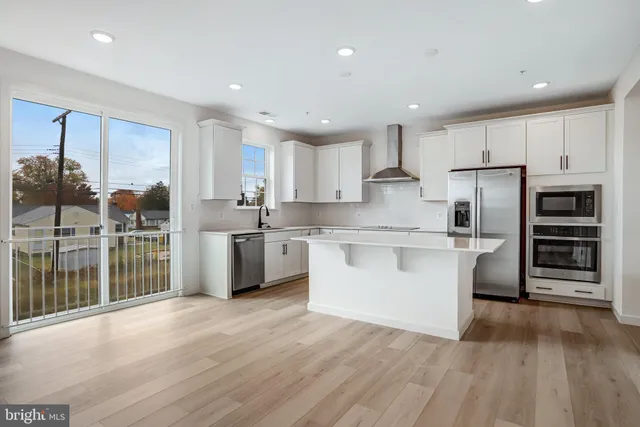 a large kitchen with stainless steel appliances and a sink
