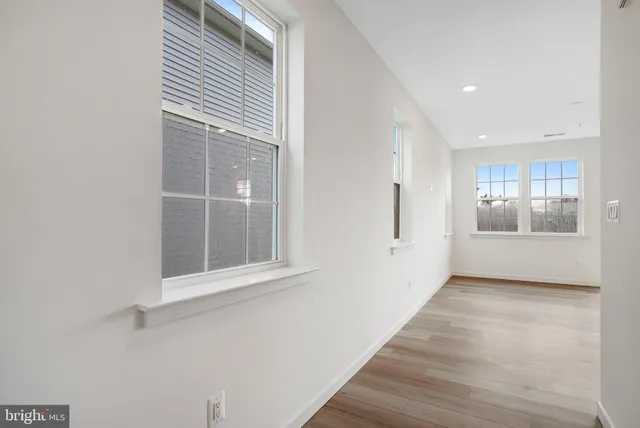 a view of kitchen with granite countertop refrigerator oven sink and white cabinets with wooden floor