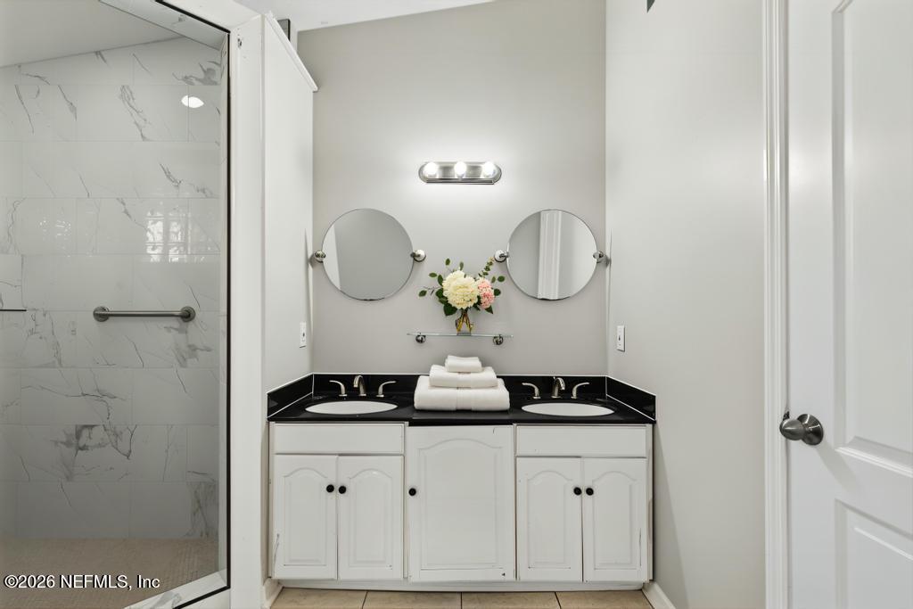 10803 Gladwynne Road Jacksonville, FL 32218 - Photo 15 of 44 a bathroom with a mirror and a shower