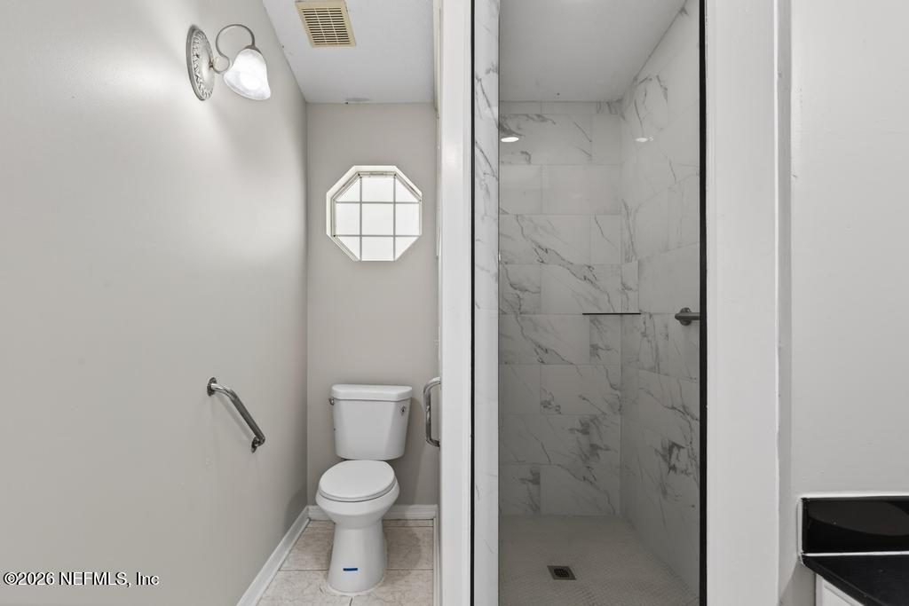 10803 Gladwynne Road Jacksonville, FL 32218 - Photo 16 of 44 a bathroom with a toilet a sink and shower