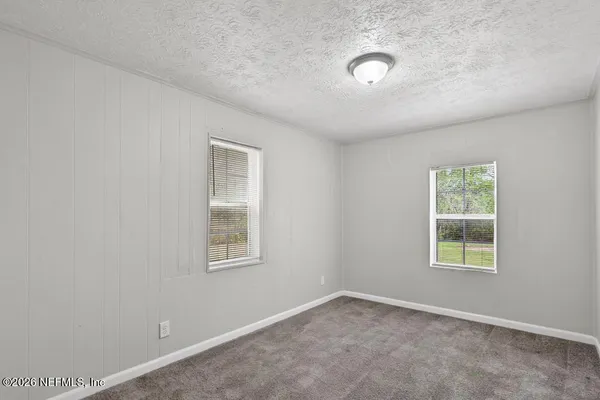 an empty room with windows and closet
