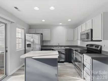 a kitchen with stainless steel appliances granite countertop a sink stove microwave and refrigerator