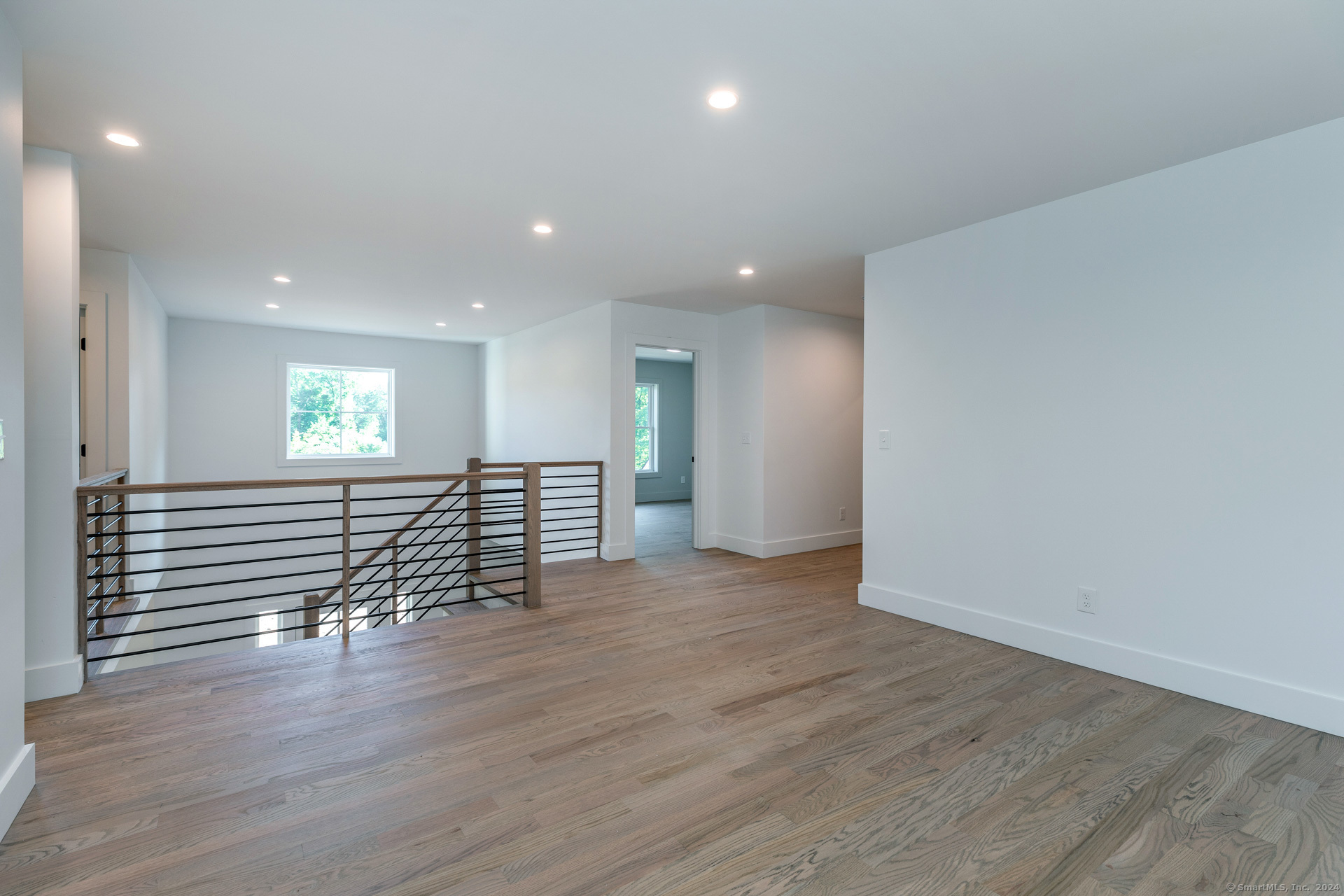 18 Sebastian Trail Newtown, CT 06470 - Photo 16 of 22 an empty room with wooden floor and windows