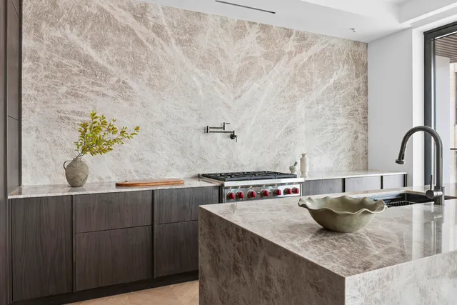 a kitchen with a stove a refrigerator and chairs