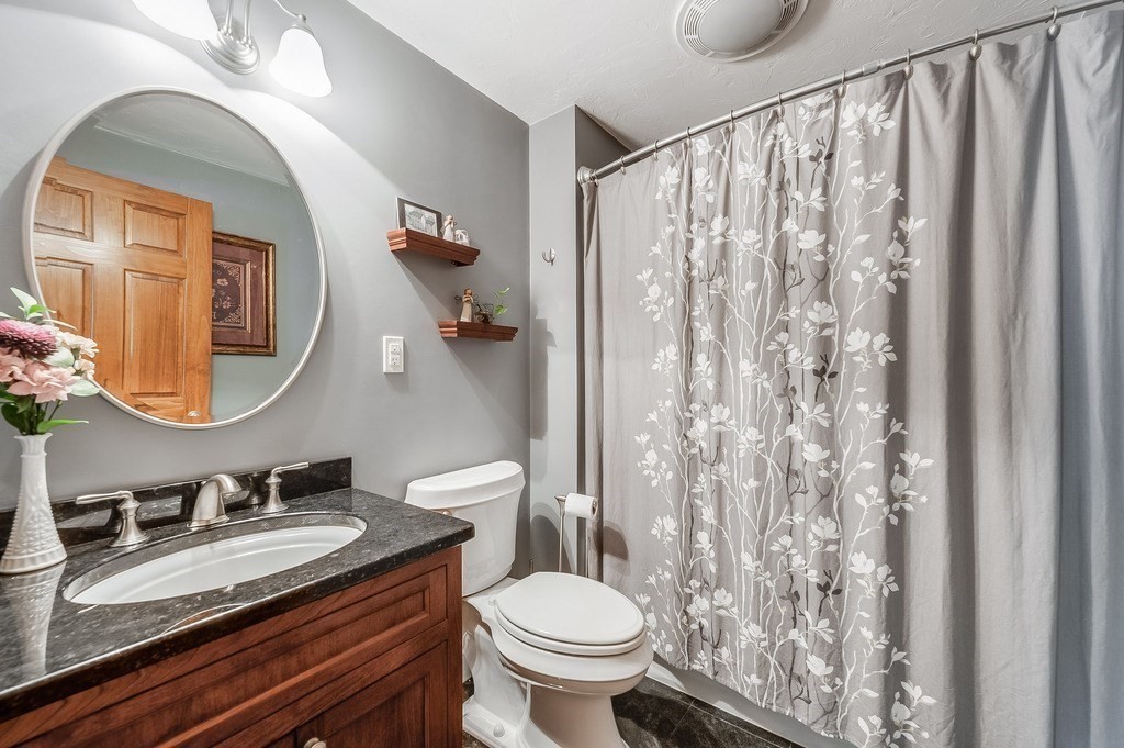 2470 West Street Wrentham, MA 02093 - Photo 16 of 42 a bathroom with a granite countertop sink vanity mirror and toilet