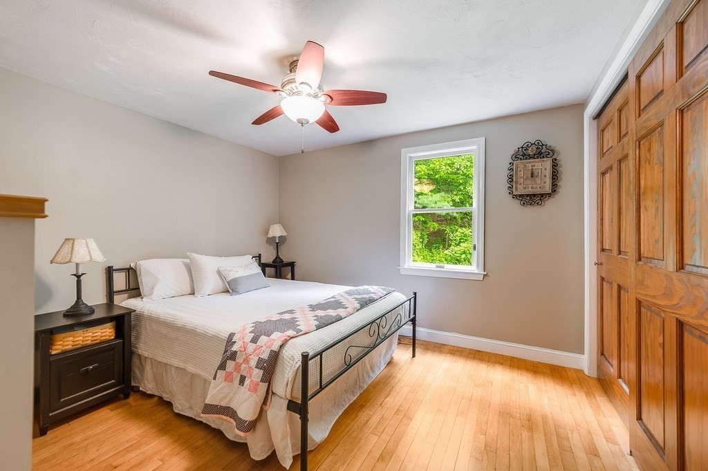 2470 West Street Wrentham, MA 02093 - Photo 17 of 42 a bedroom with a bed and a chandelier
