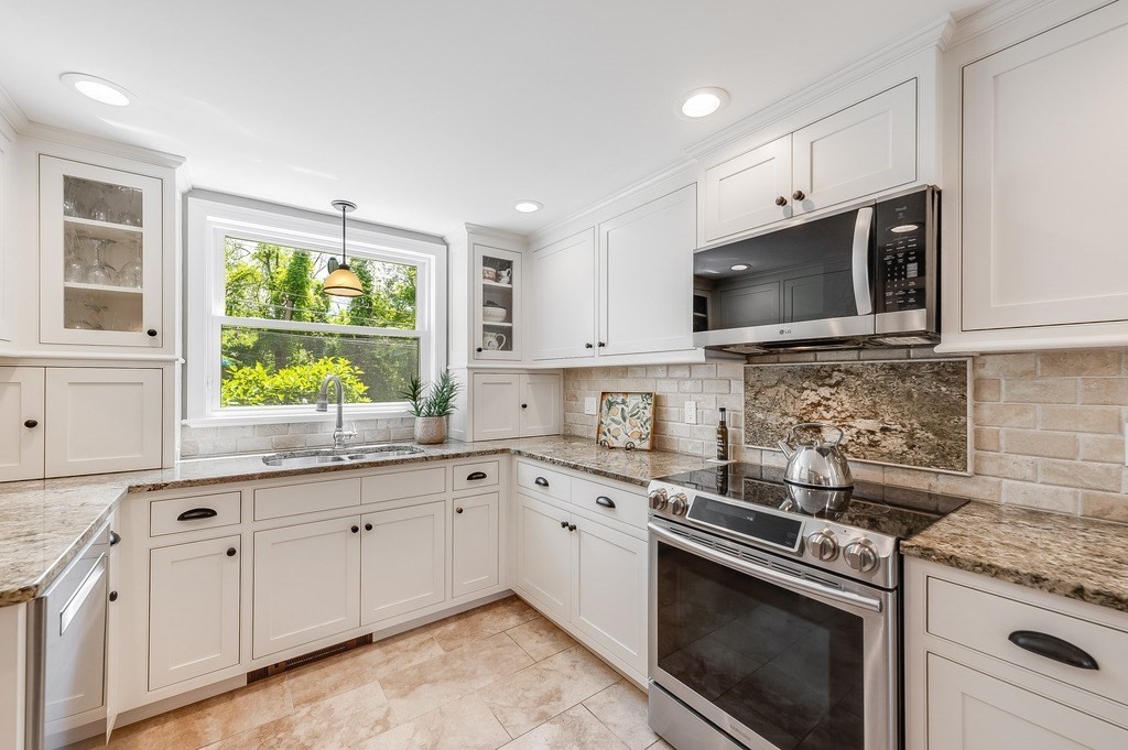2470 West Street Wrentham, MA 02093 - Photo 7 of 42 a kitchen with granite countertop white cabinets a sink a window and stainless steel appliances