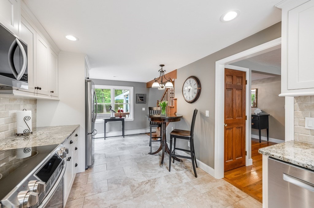 2470 West Street Wrentham, MA 02093 - Photo 8 of 42 a very nice looking kitchen with granite countertop a stove a sink a window and dining table