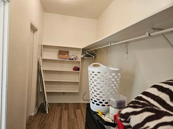 a view of walk in closet with clothes and shoes